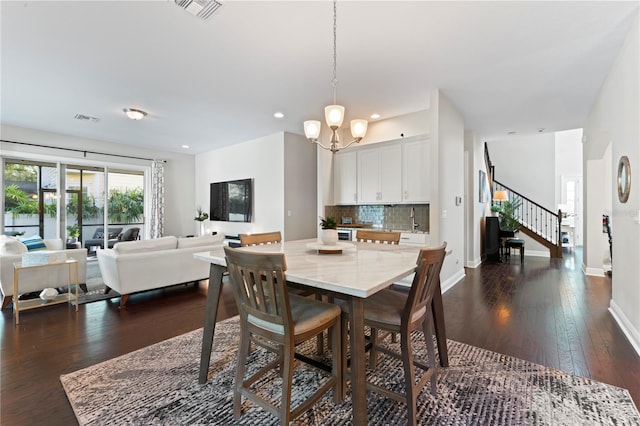 dining room featuring a chandelier and dark wood-type flooring