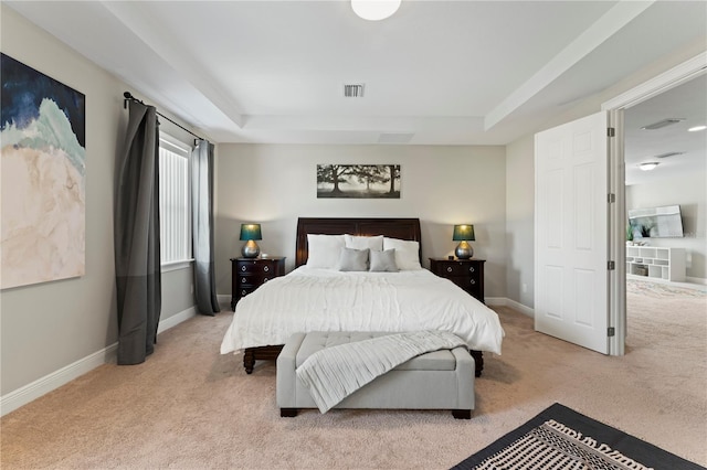 bedroom featuring a raised ceiling and light colored carpet