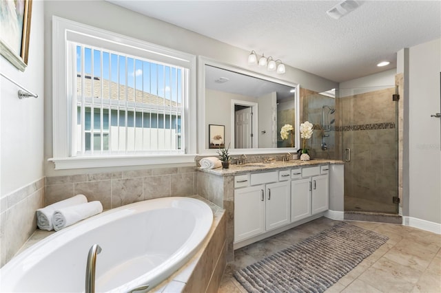 bathroom with tile patterned flooring, vanity, a textured ceiling, and shower with separate bathtub