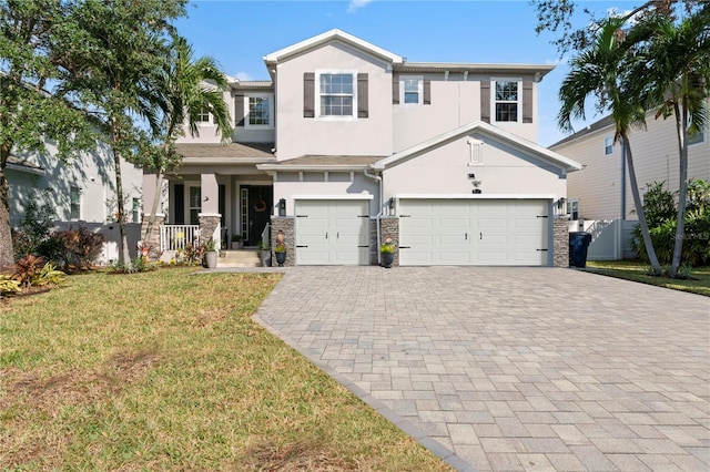 view of front of home featuring covered porch, a front yard, and a garage