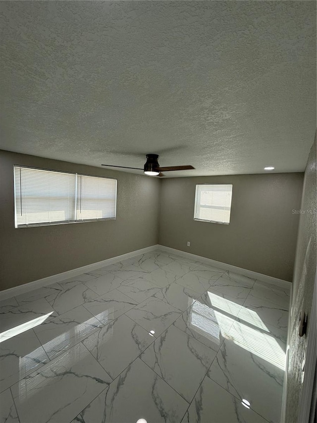 spare room with ceiling fan and a textured ceiling