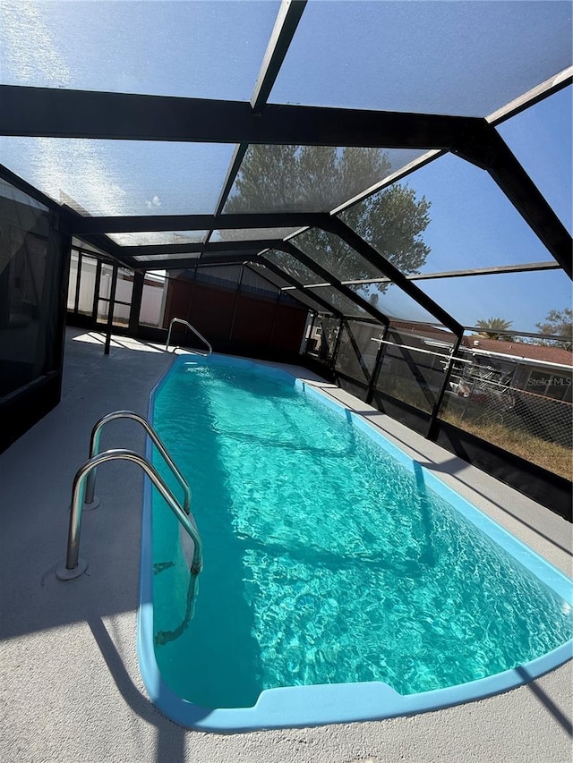 view of pool with a patio and glass enclosure