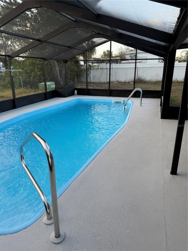 view of swimming pool featuring a lanai