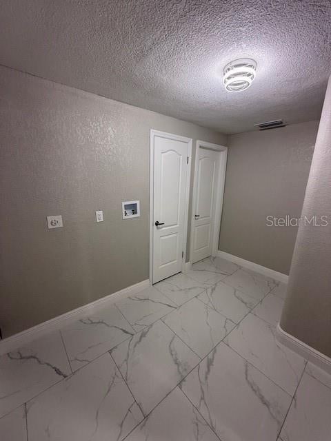 unfurnished room featuring a textured ceiling