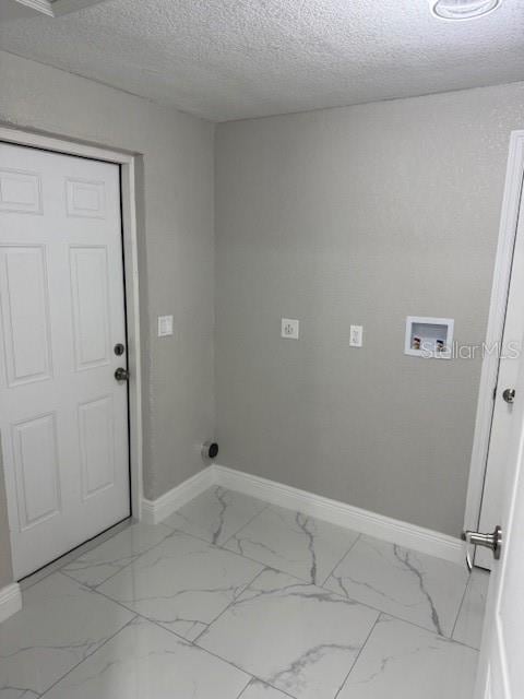 clothes washing area featuring a textured ceiling and hookup for a washing machine