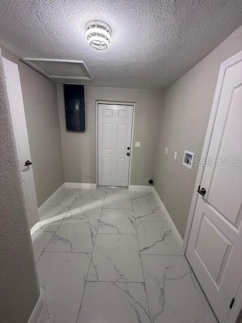 laundry room featuring hookup for a washing machine, a textured ceiling, and electric panel