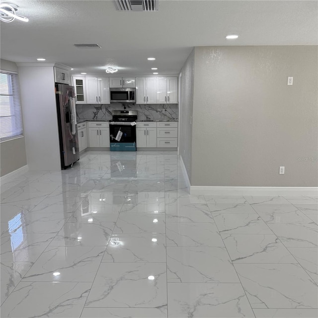 kitchen featuring white cabinets, decorative backsplash, a textured ceiling, and appliances with stainless steel finishes