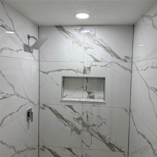 room details featuring a textured ceiling and walk in shower