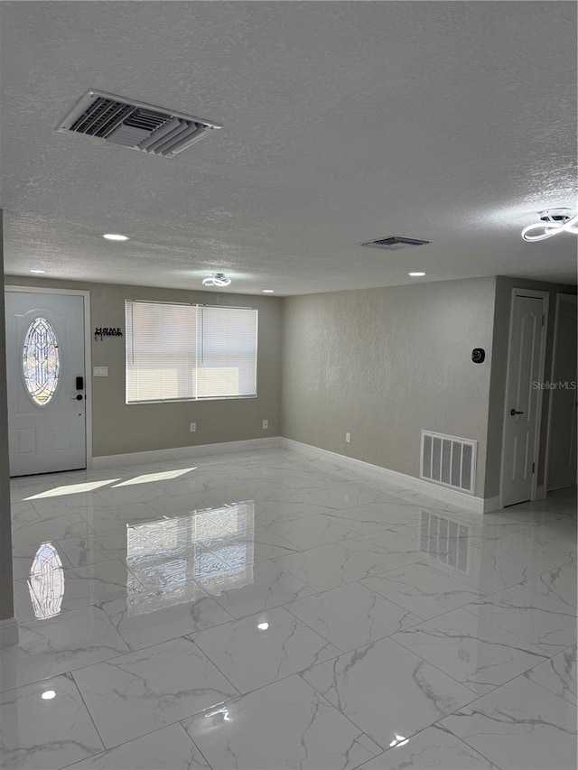 foyer entrance with a textured ceiling