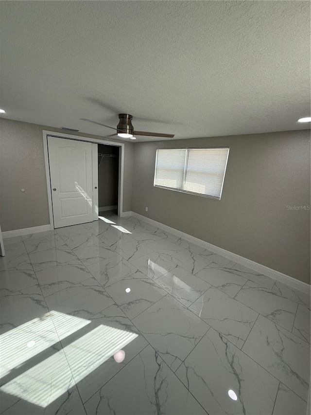 spare room featuring a textured ceiling and ceiling fan