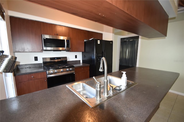 kitchen with light tile patterned flooring, stainless steel appliances, and sink