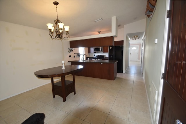 kitchen with sink, stainless steel appliances, an inviting chandelier, an island with sink, and decorative light fixtures