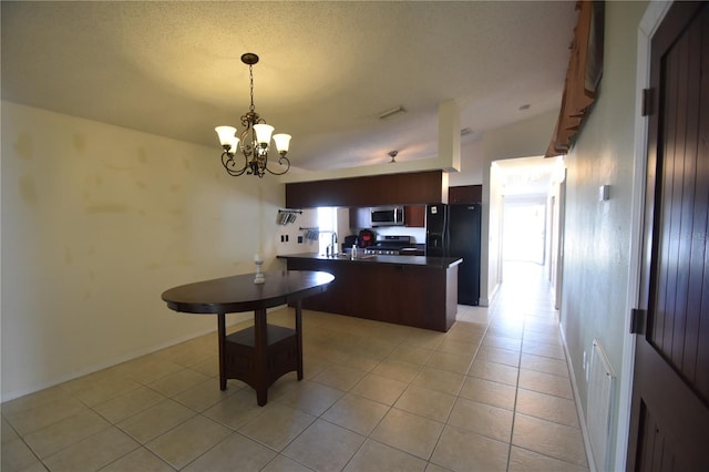 kitchen with stainless steel appliances, a notable chandelier, kitchen peninsula, a textured ceiling, and light tile patterned floors