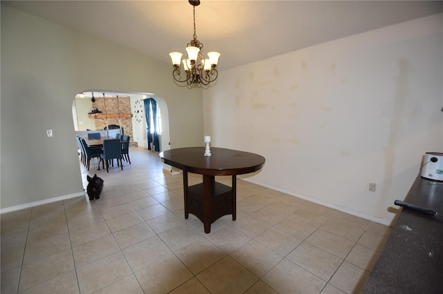 dining room with light tile patterned floors, a chandelier, and vaulted ceiling