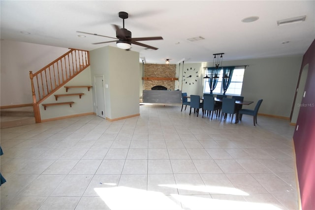 dining area with ceiling fan, a fireplace, and light tile patterned floors