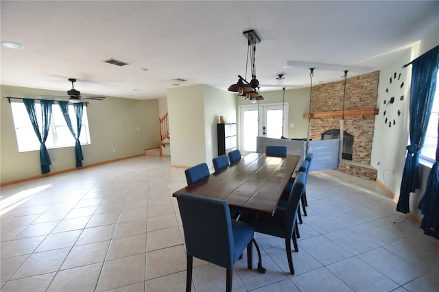 dining space featuring light tile patterned flooring, a fireplace, and a wealth of natural light