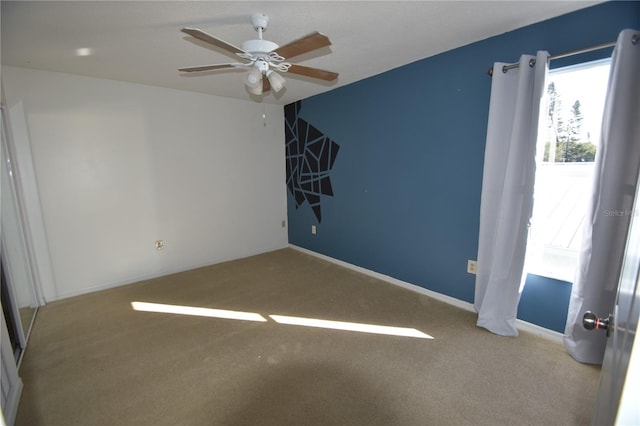 spare room with ceiling fan and light colored carpet