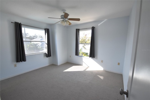 empty room featuring light colored carpet, plenty of natural light, and ceiling fan