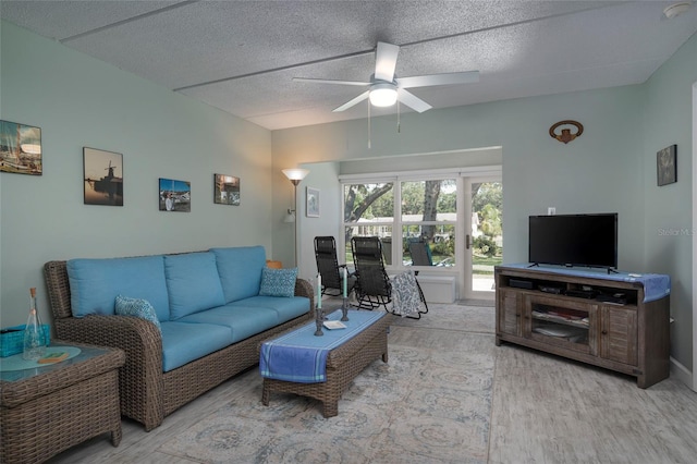 living room featuring a textured ceiling, light hardwood / wood-style floors, and ceiling fan