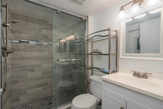 bathroom featuring vanity, an enclosed shower, a textured ceiling, and toilet