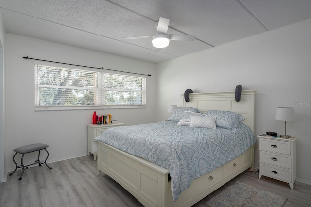 bedroom featuring light wood-type flooring, multiple windows, and ceiling fan