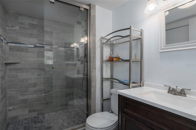 bathroom featuring vanity, toilet, a textured ceiling, and walk in shower