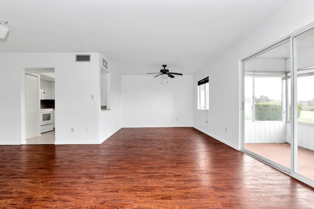 unfurnished living room with ceiling fan, a textured ceiling, and dark hardwood / wood-style flooring