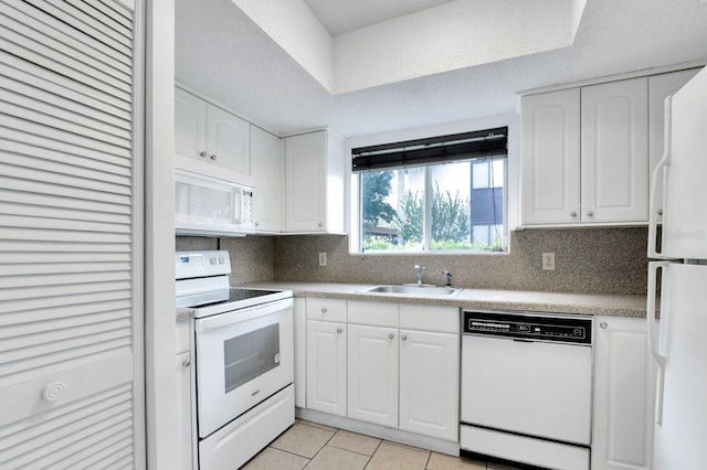 kitchen featuring sink, a textured ceiling, light tile patterned floors, white appliances, and white cabinets