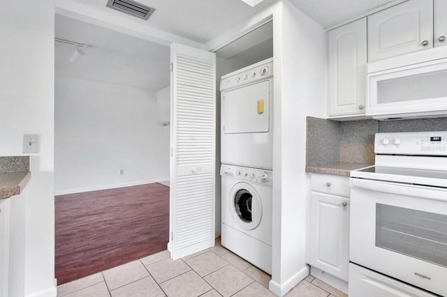 laundry area featuring stacked washer and clothes dryer and light wood-type flooring