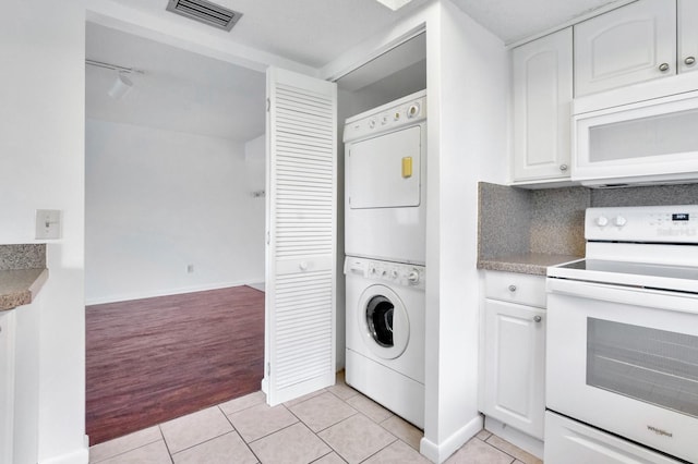 554 Fairways Cir Unit A, Ocala, FL 34472 - washroom with stacked washer and clothes dryer and light tile patterned floors
