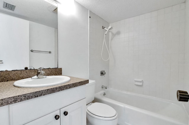 full bathroom with toilet, tiled shower / bath combo, vanity, and a textured ceiling