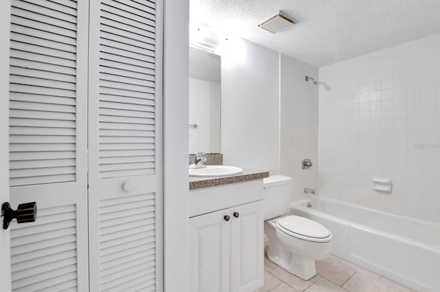 full bathroom featuring toilet, tile patterned floors, tiled shower / bath, a textured ceiling, and vanity