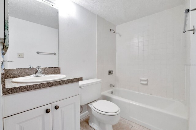 full bathroom with tile patterned floors, vanity, a textured ceiling, toilet, and tiled shower / bath