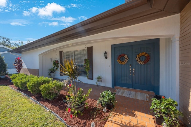 view of exterior entry featuring covered porch