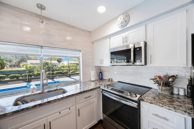 kitchen with white cabinetry, stainless steel appliances, sink, and tasteful backsplash