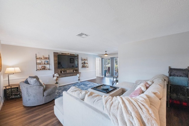 living room with ornamental molding, wood-type flooring, ceiling fan, and a textured ceiling