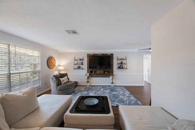 living room featuring dark wood-type flooring and a textured ceiling