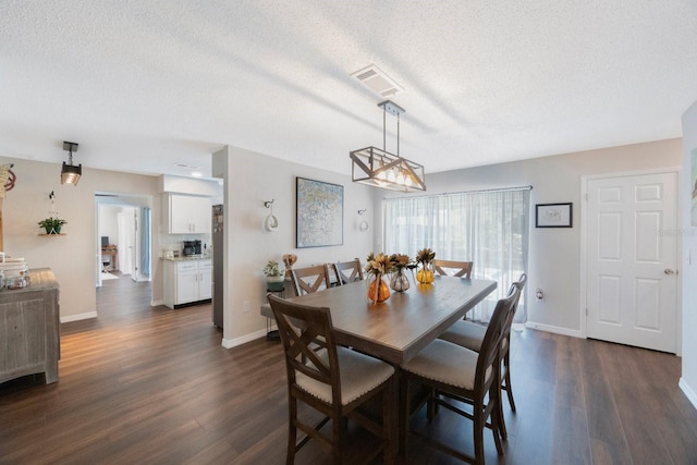 dining space with dark hardwood / wood-style floors and a textured ceiling