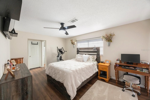 bedroom featuring a textured ceiling, ceiling fan, and dark hardwood / wood-style floors