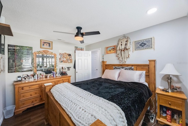 bedroom with a textured ceiling, dark hardwood / wood-style flooring, and ceiling fan