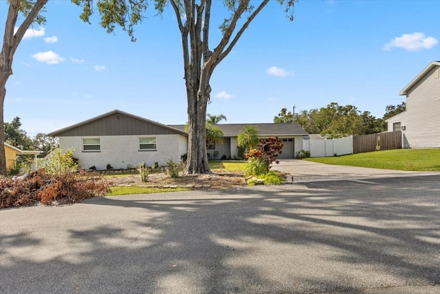 ranch-style home featuring a garage and a front yard