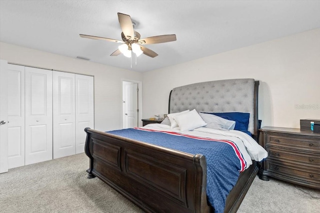 carpeted bedroom with ceiling fan and a closet