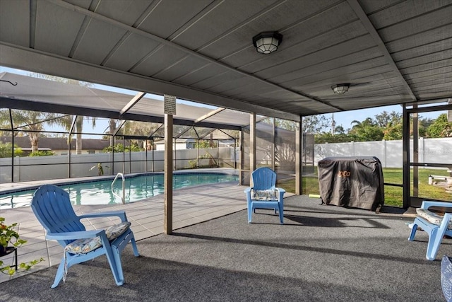 view of pool with glass enclosure, a patio, and a grill