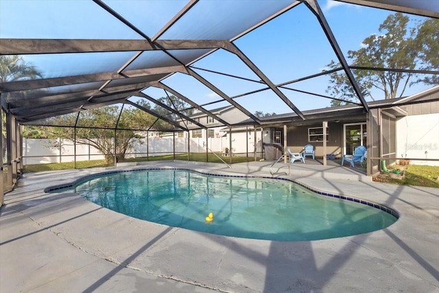 view of swimming pool featuring glass enclosure and a patio area