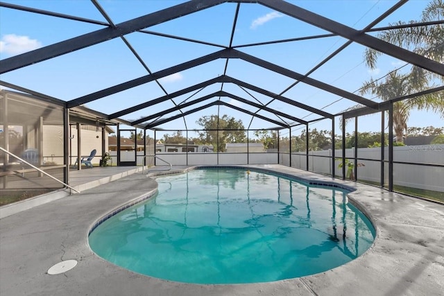 view of swimming pool featuring glass enclosure and a patio