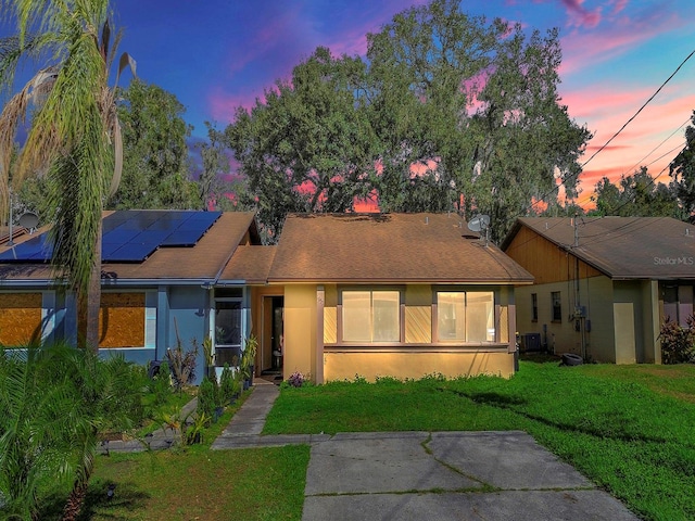 view of front facade with solar panels and a yard