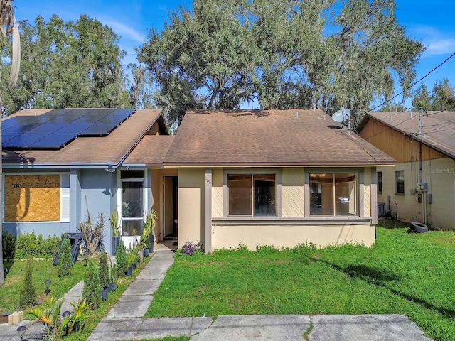 view of front of house featuring a front yard and solar panels