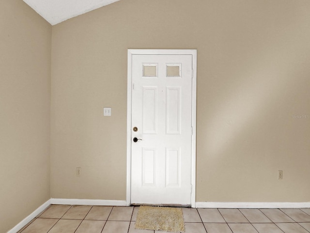 tiled empty room with vaulted ceiling