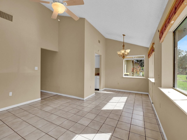 unfurnished room with ceiling fan with notable chandelier, a textured ceiling, high vaulted ceiling, and light tile patterned flooring