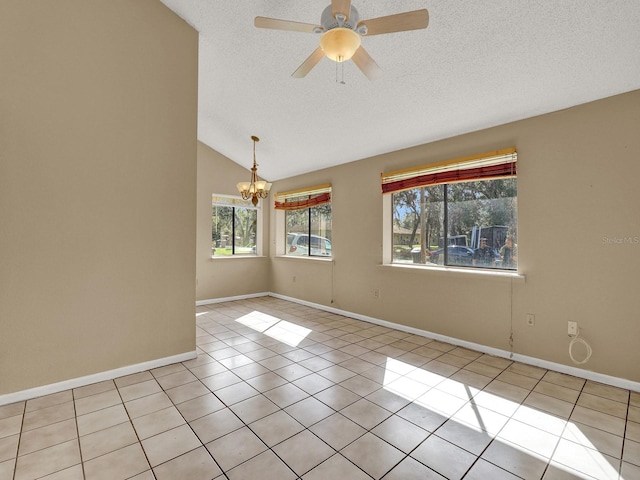 tiled empty room featuring a textured ceiling, ceiling fan with notable chandelier, and vaulted ceiling